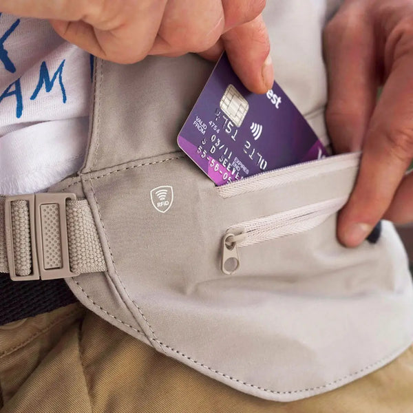 Person placing a bank card in to their Lifeventure RFiD multi pocket waist wallet whilst on holiday