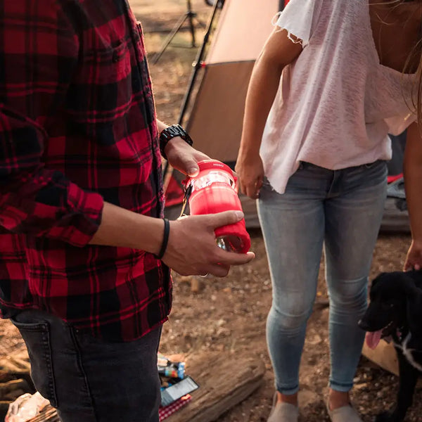 Lifestyle image of a man holding a NEBO POPPY 300 Lumens LED Lantern and Torch at the campsite