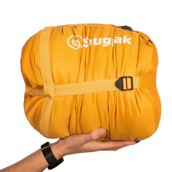 Snugpak Sleeper Expedition Sleeping Bag packed in its compression stuff sack and held in someones hand as a size comparison