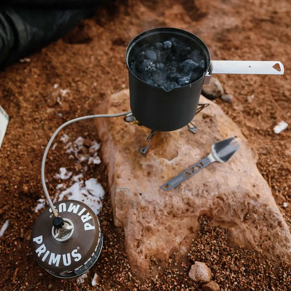 Expedition stove attached to a Winter Gas canister to melt ice for drinking water in winter