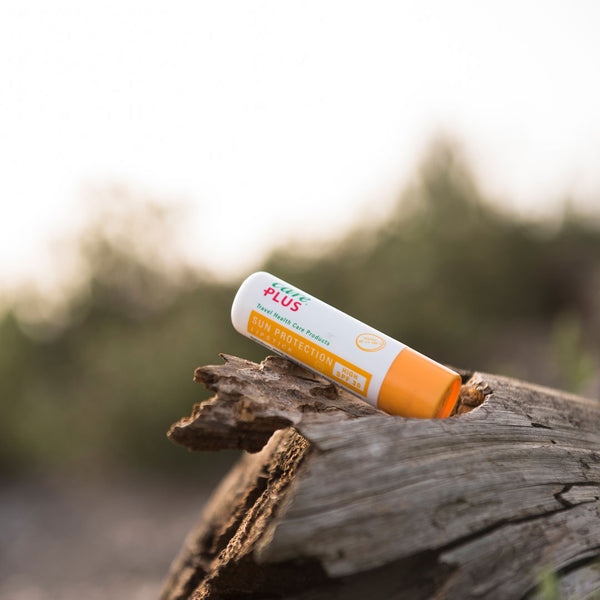 Lifestyle image of a Care Plus lip slave sun protection stick photographed on a log