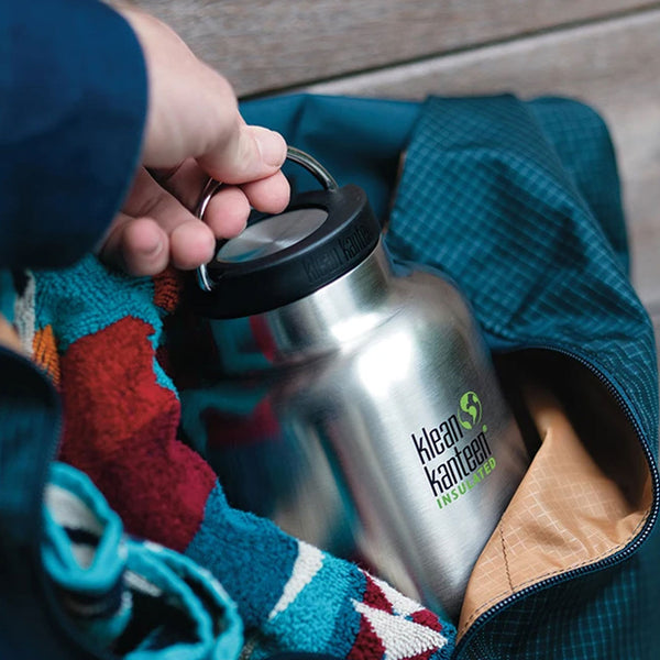 Lifestyle shot of a hand pulling out a Klean kanteen insulated stainless steel wide mouth bottle  by the carry handle