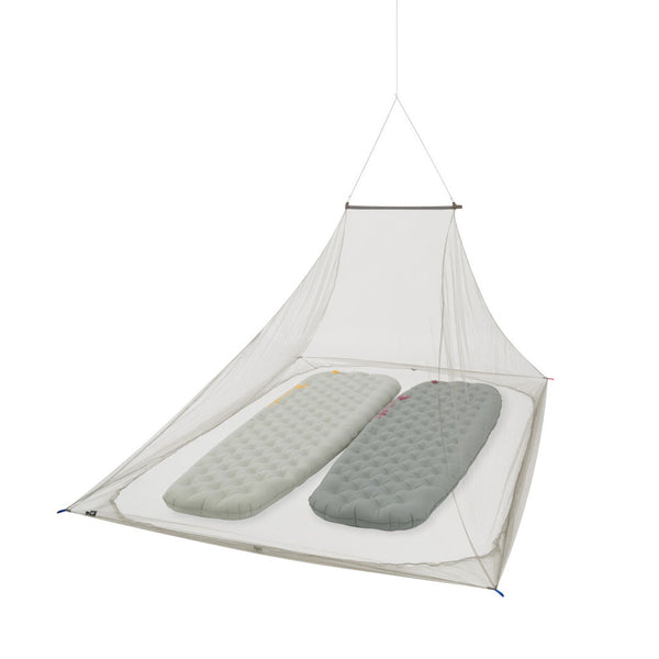 Studio shot on a white background of a Sea To Summit Nano Pyramid Double mosquito net hanging from the ceiling with two inflatable camp beds inside